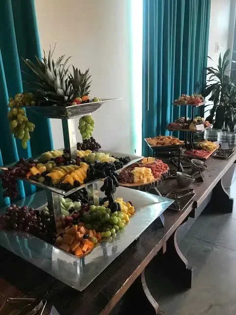 Elegant buffet with multi-tiered fruit platter, cured meats, and cheeses.