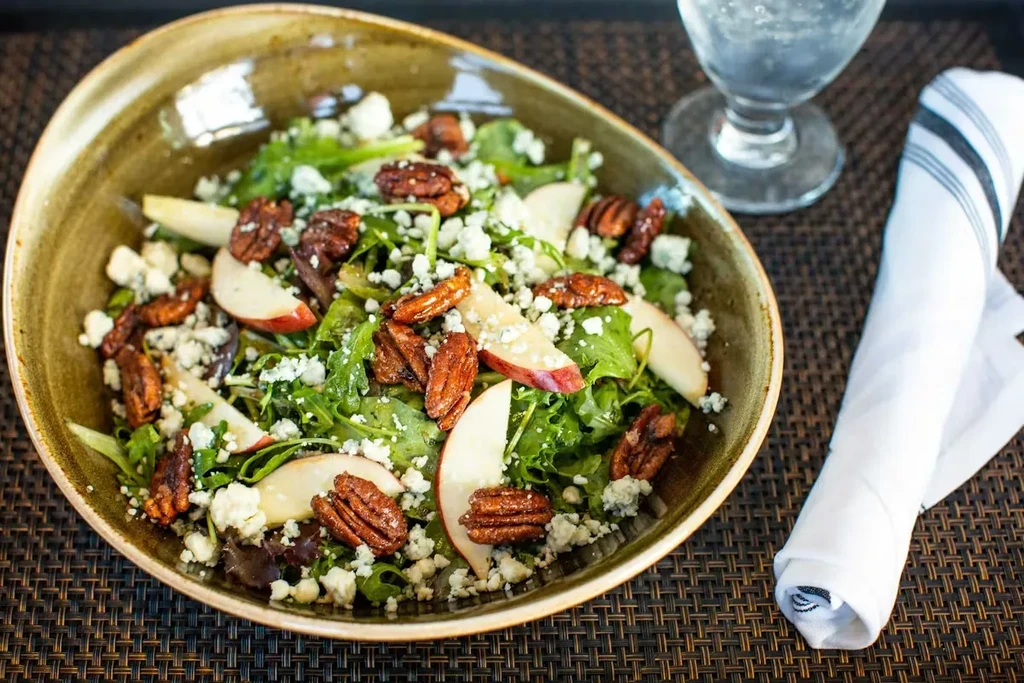 Salad with greens, candied pecans, red apple, and blue cheese.