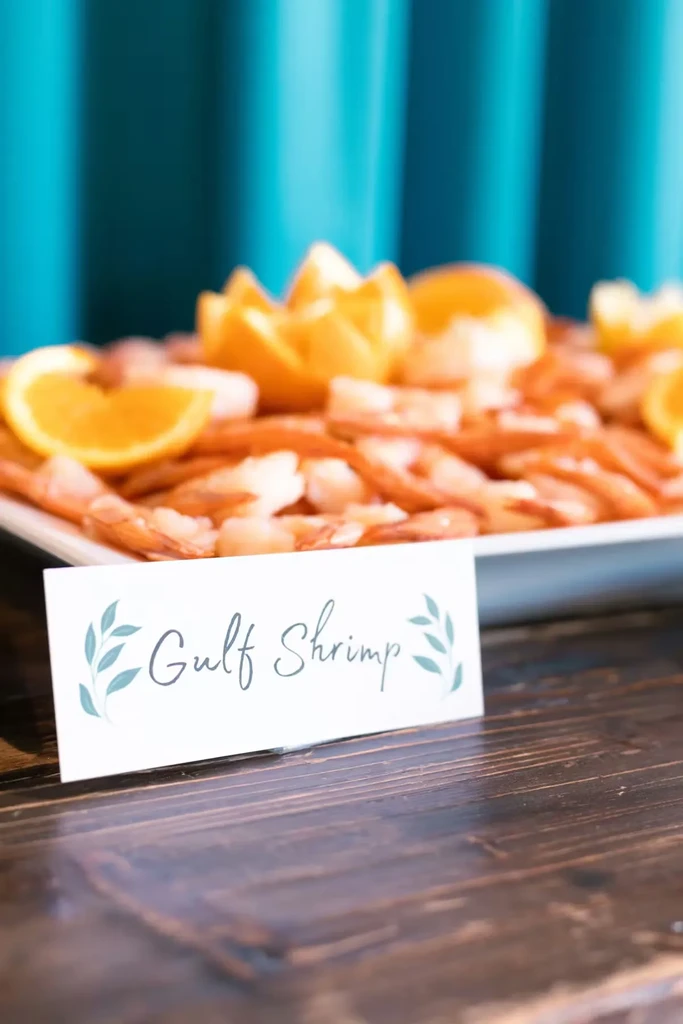 Platter of cooked Gulf shrimp garnished with orange slices.