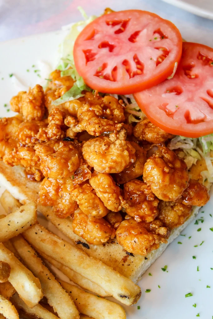 Fried shrimp po'boy with lettuce, tomato, and french fries.