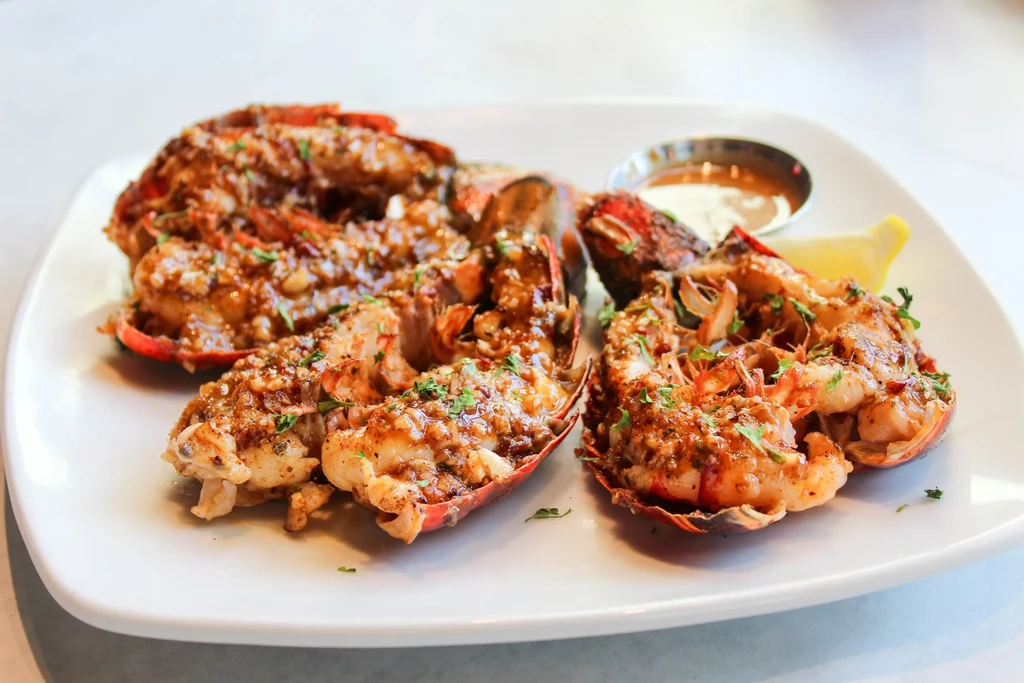 Grilled lobster or crayfish tails with herbs, lemon, and sauces.