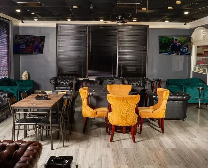 Sophisticated lounge interior with diverse seating, dark walls, and TVs.