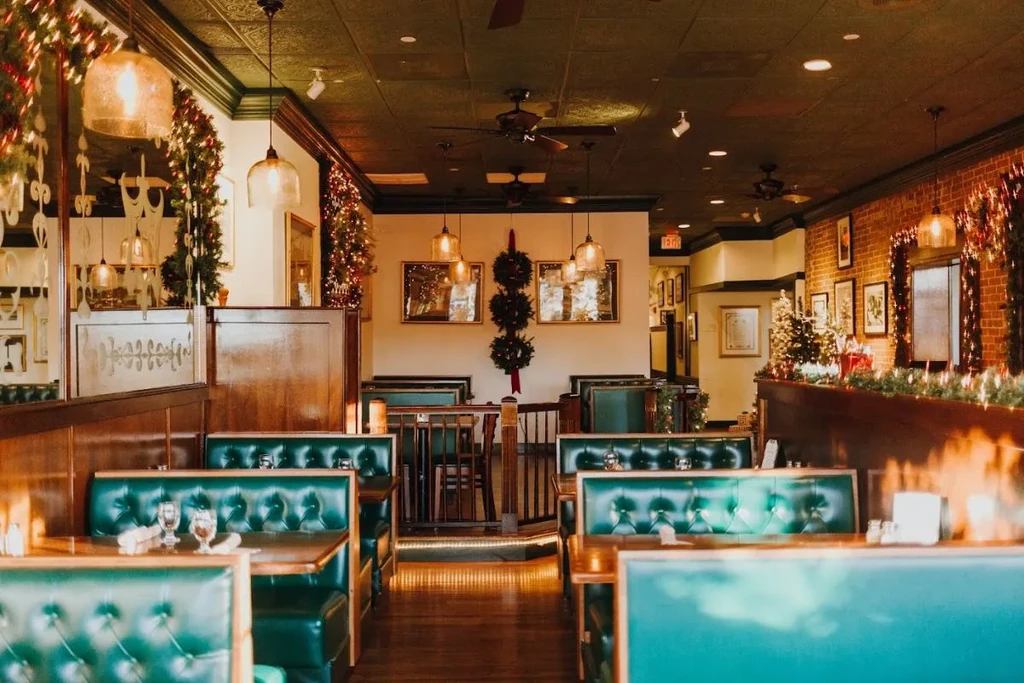 Restaurant dining area with warm lighting and festive Christmas decorations.