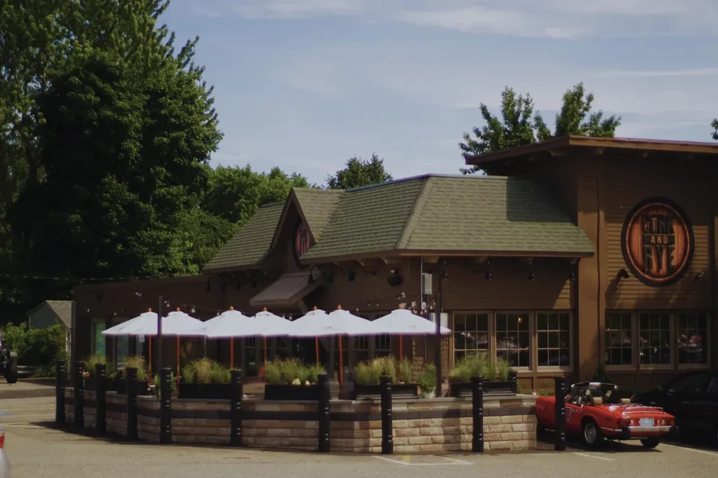 Rustic COAL AND RYE restaurant with shaded patio and a red classic car.