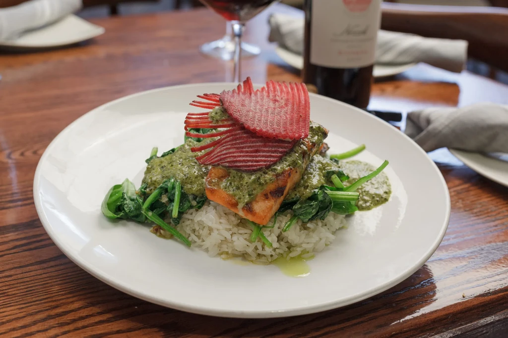 Grilled fish, green pesto, spinach, rice, and wavy vegetable crisps.