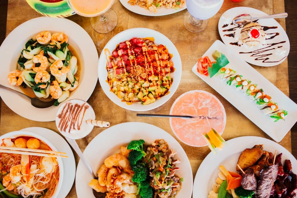 Overhead view of a diverse Asian food and drink spread.