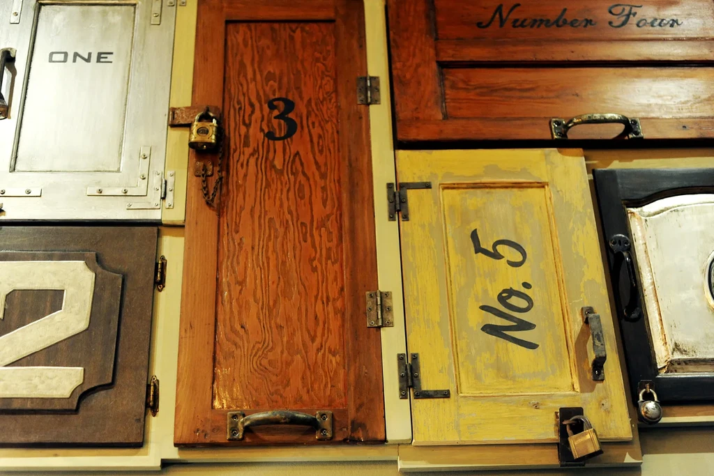 Wall of rustic, numbered wooden panels with various hardware.