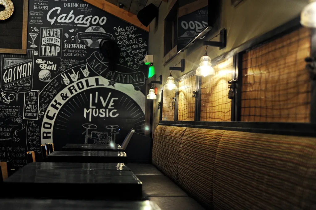 Cozy venue interior with banquette seating and music chalkboard.