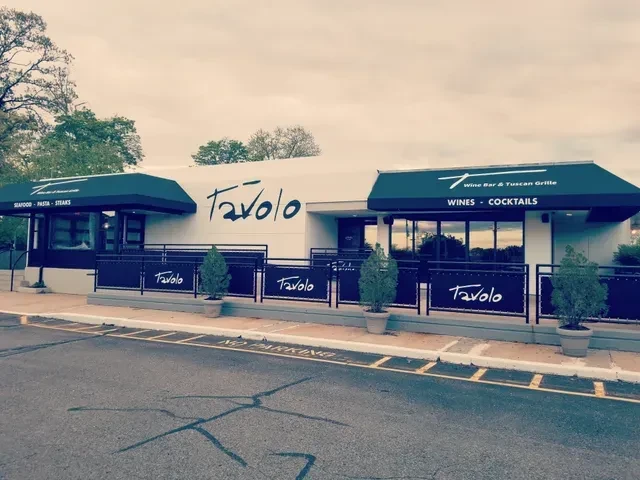 Tavolo restaurant exterior: modern white building, black awnings, front fence.