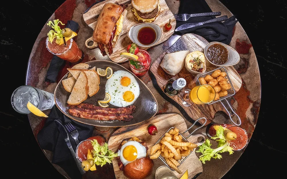 Overhead shot of diverse breakfast and brunch items on a marble table.