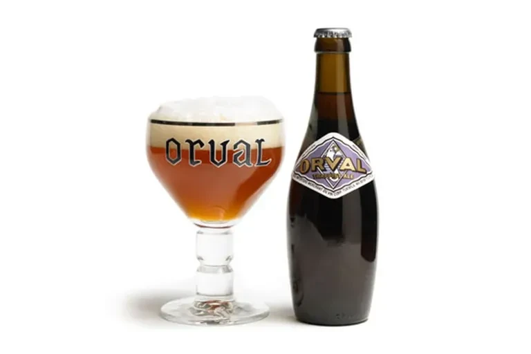 Orval Trappist ale in branded glass with foam and bottle.