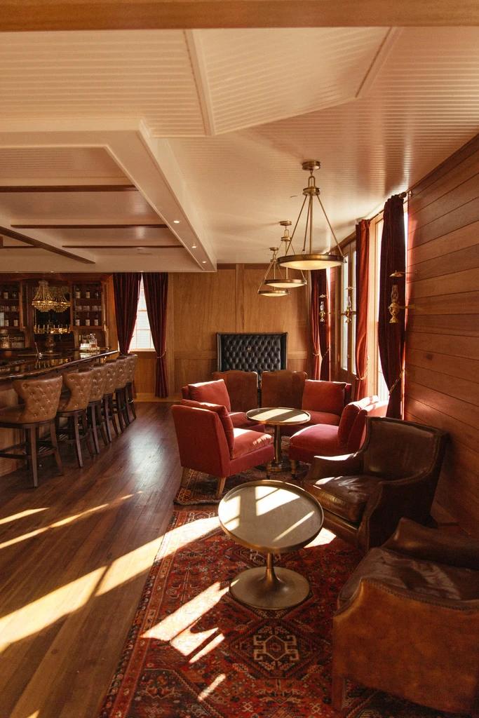 Classic bar and lounge interior with velvet, wood, and brass details.
