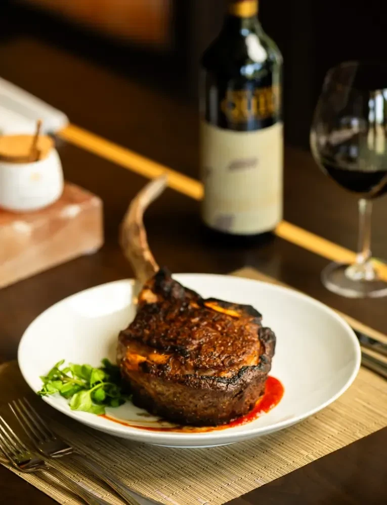 Seared bone-in steak, red sauce, green herbs, wine, and Himalayan salt.