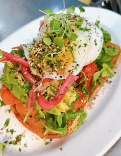 Avocado toast with poached egg, pickled onions, and bagel seasoning.