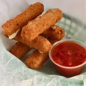 Golden mozzarella sticks in a basket with melted cheese, red dipping sauce.