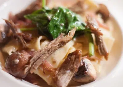 Pasta with shredded meat, spinach, mushrooms, and creamy sauce.