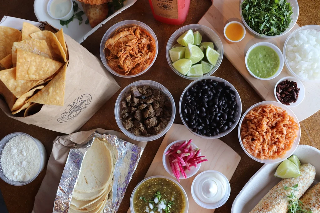 Overhead view of a colorful Mexican taco bar spread.
