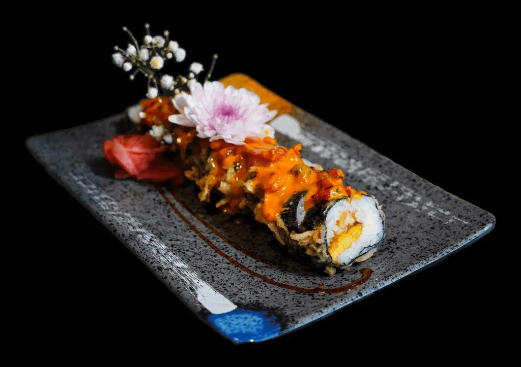 Tempura sushi roll with orange sauce, pink flower, and pickled ginger.