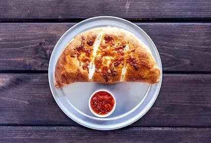 Baked golden-brown cheese bread with melted cheese and red dipping sauce.