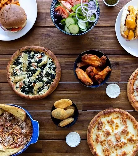 Overhead shot of a diverse food spread on a rustic wooden table.