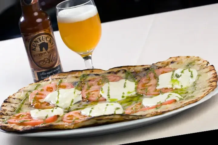Grilled flatbread with tomatoes, mozzarella, pesto, and Kentucky Bourbon Barrel Ale.