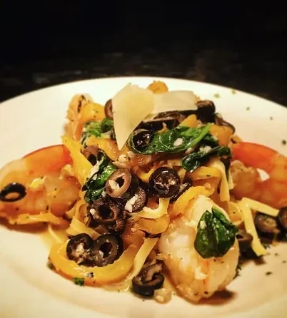 Gourmet pasta with shrimp, bell pepper, spinach, olives, and Parmesan.