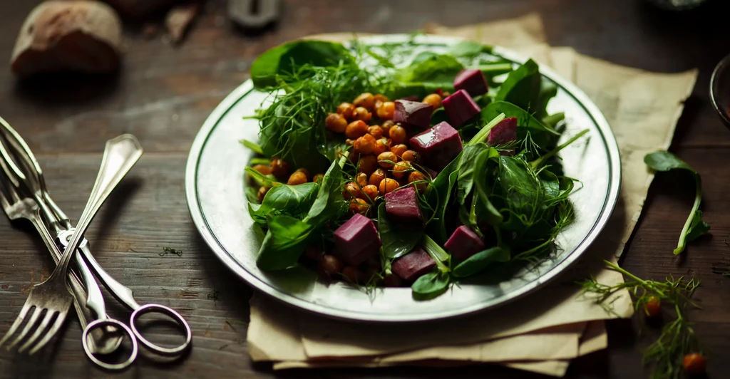 Close-up of a fresh salad with greens, roasted chickpeas, beets.