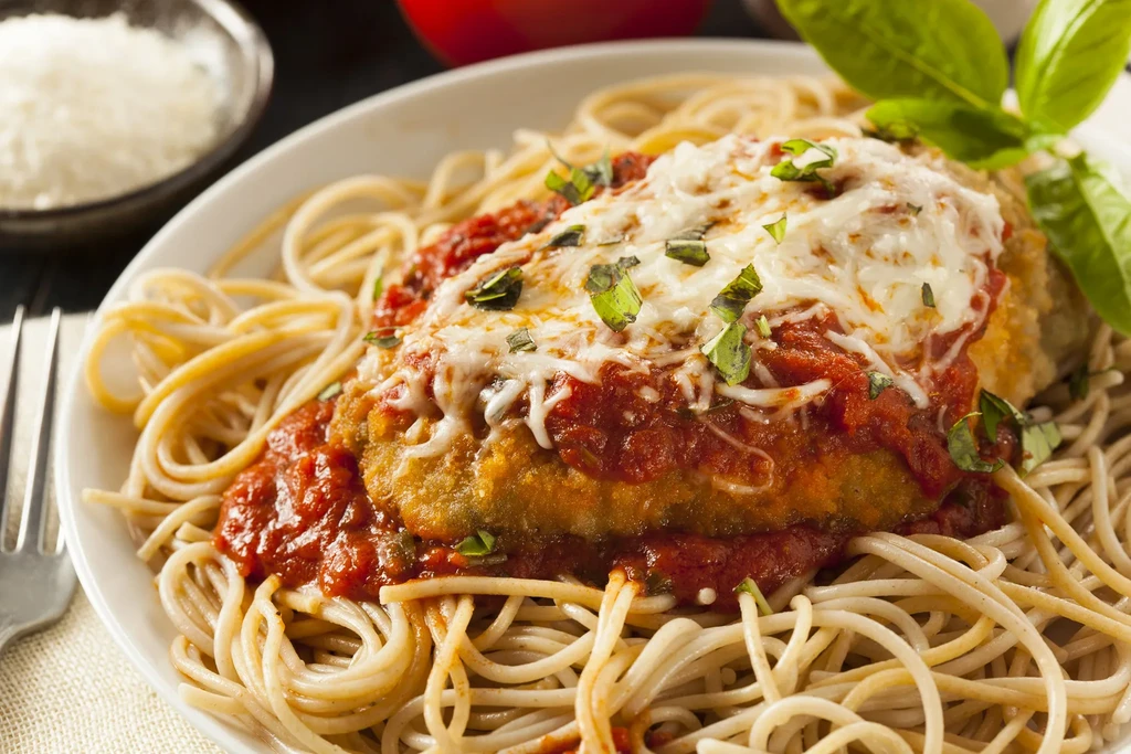 Chicken or eggplant parmesan with marinara, mozzarella, basil, and spaghetti.