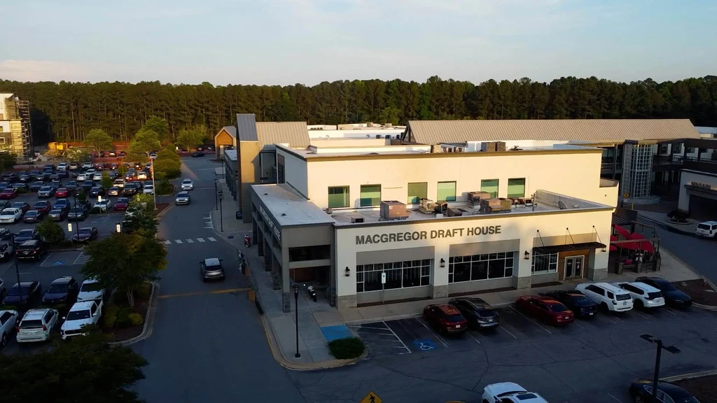 High-angle view of Macgregor Draft House, busy parking lot, golden light.