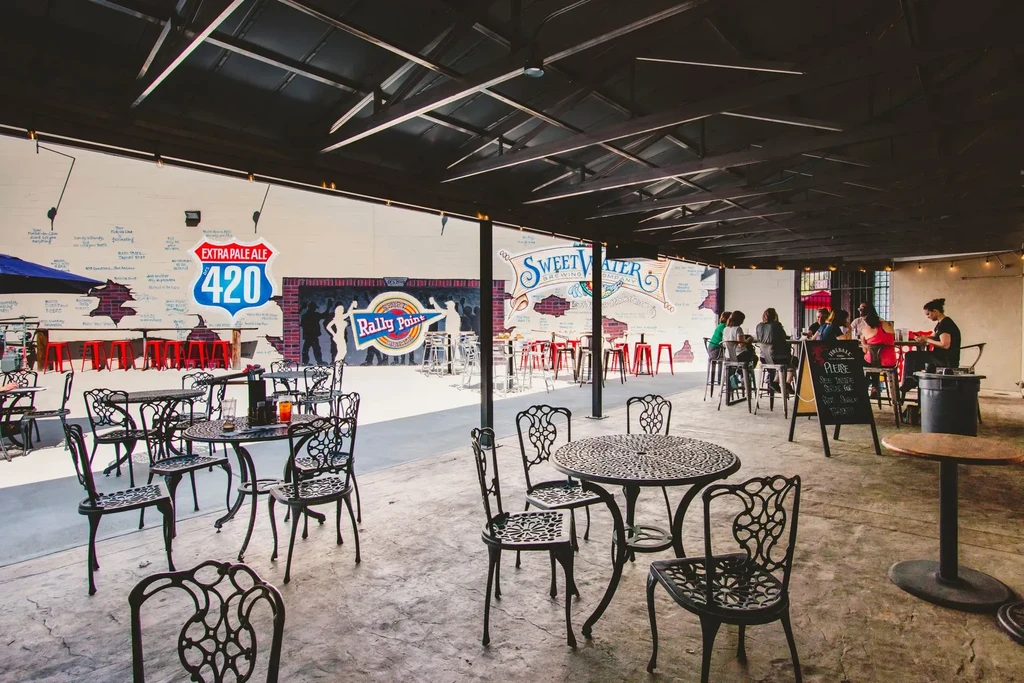 Lively restaurant patio with diverse seating, colorful murals, and branding.