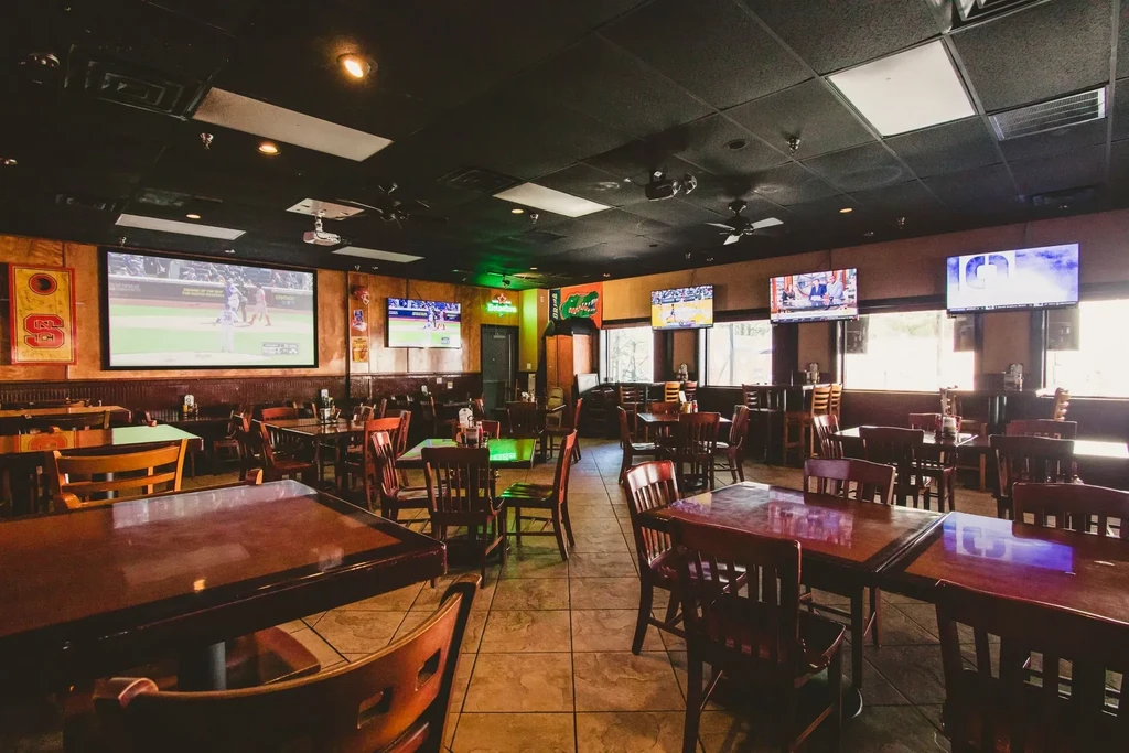 Empty sports bar with multiple screens displaying baseball games.