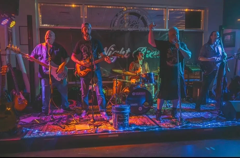 "Violet Brew" band performs live on a vibrantly lit stage.