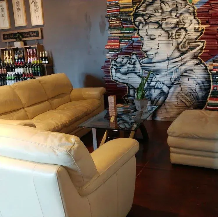Artistic restaurant lounge with leather seating and a book mural.