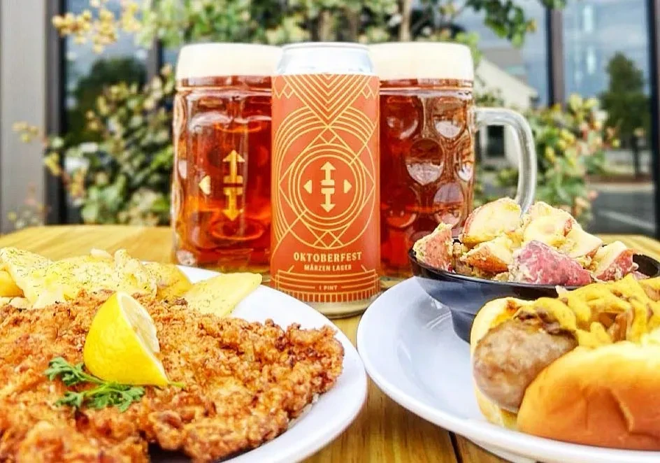 Schnitzel, hot dog, potatoes, and Oktoberfest Märzen lager beer on table.