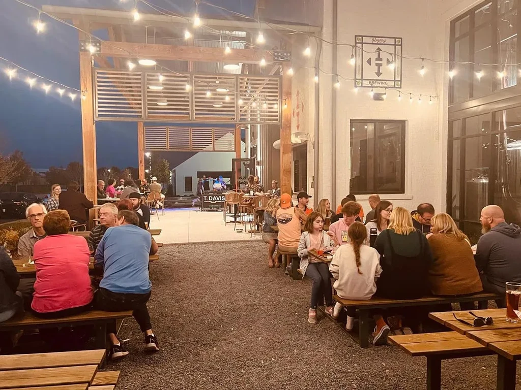Heyday Brewing patio at night with string lights, patrons, and live music.