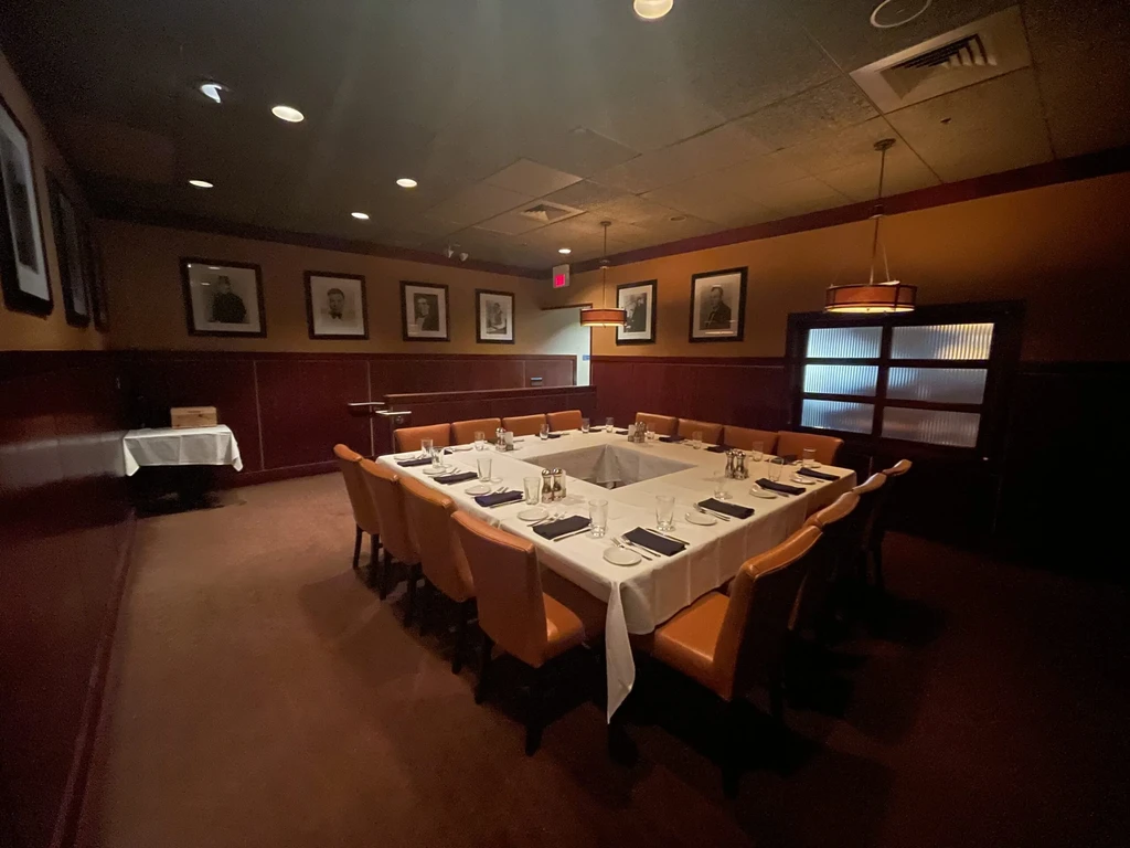 Empty private dining room with a large set table and two-toned walls.