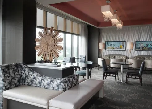 Sophisticated modern interior with patterned sofa, starburst sculpture, and abstract art.