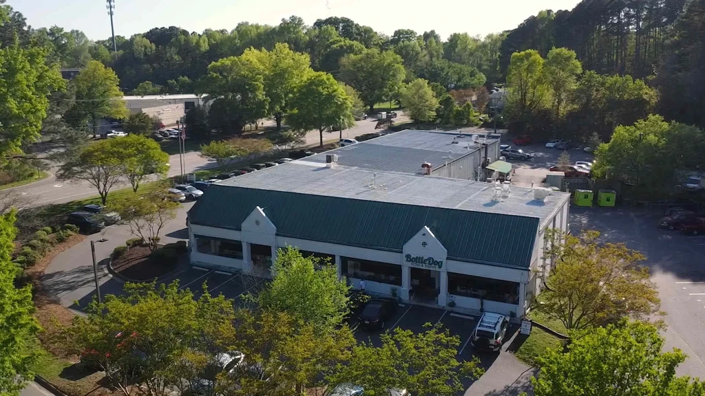 Aerial view of BottleDog Bites & Brews with green roof and parking lot.