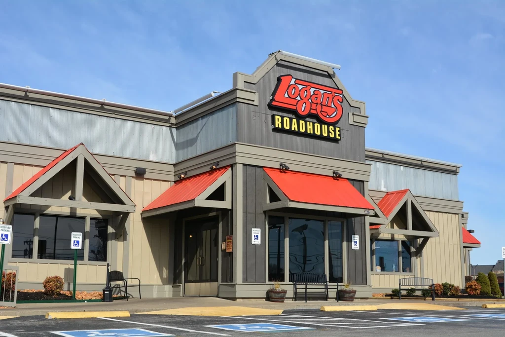 Logan's Roadhouse exterior, roadhouse theme, under clear sky, empty parking lot.
