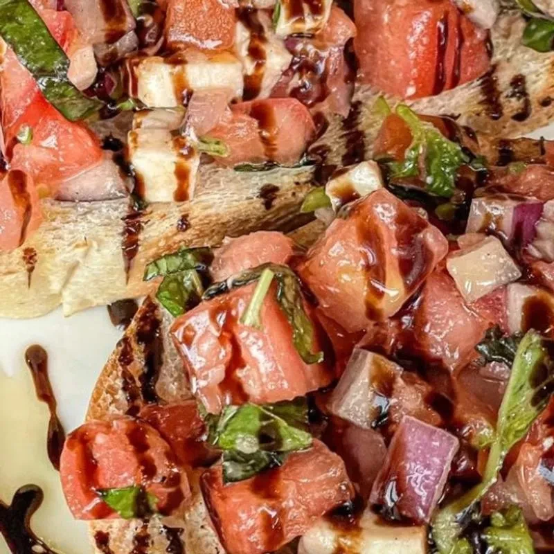Bruschetta with diced tomatoes, fresh basil, and balsamic glaze.