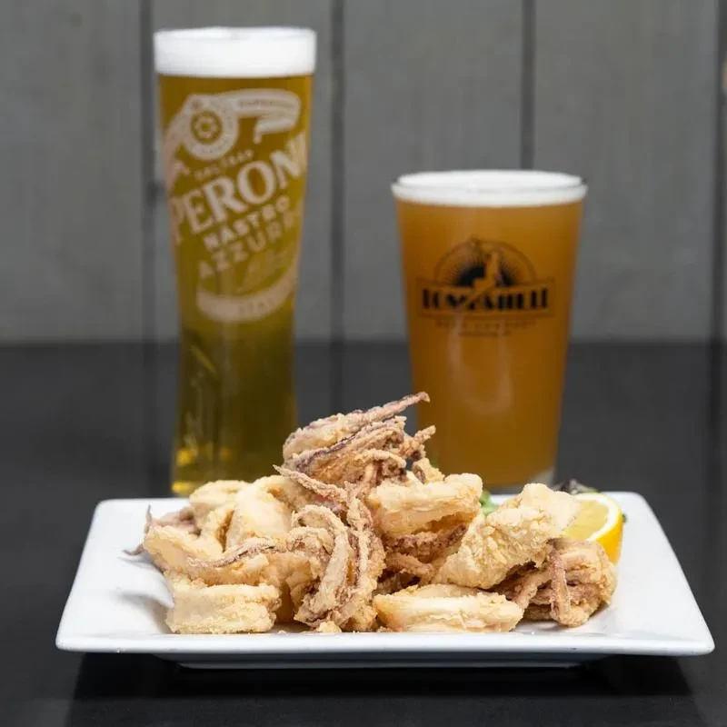 Fried calamari rings and tentacles, lemon, served with two beers.
