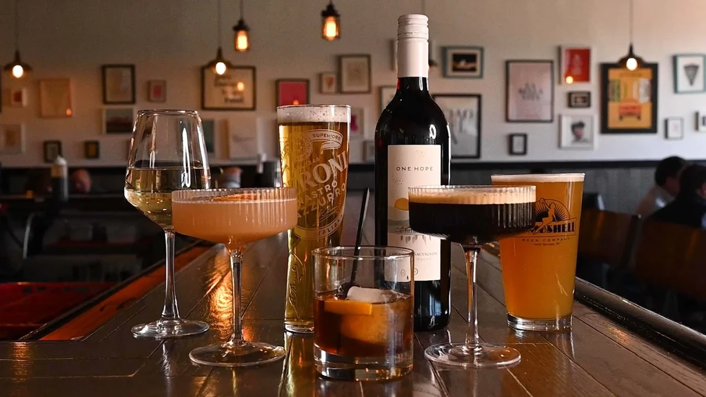 Close-up of assorted alcoholic beverages on a dark wooden bar.