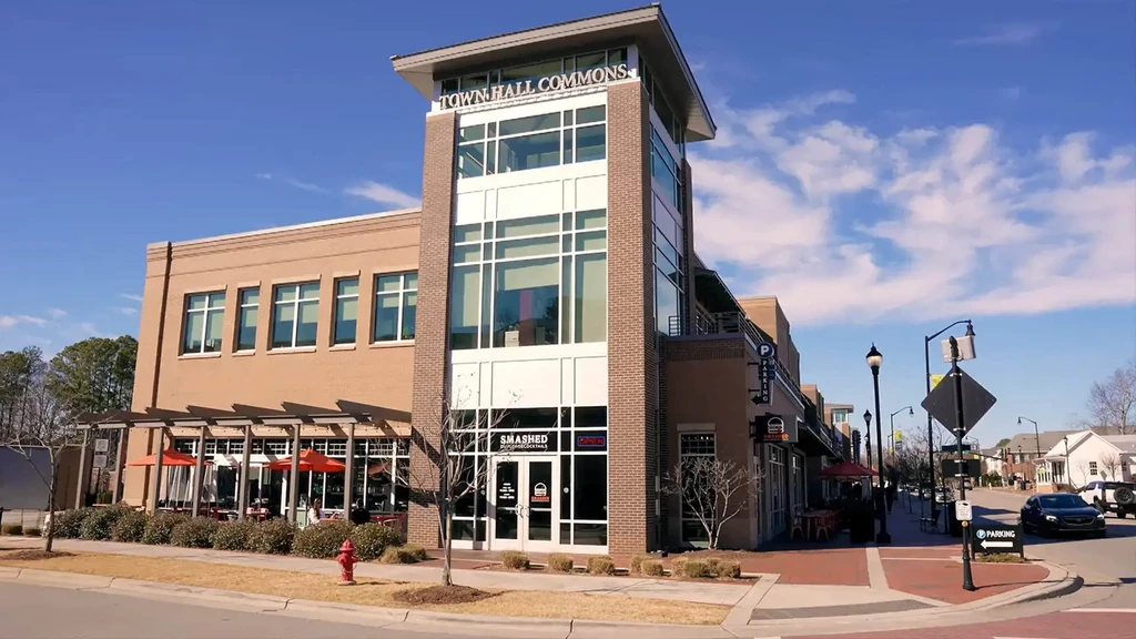 Modern TOWN HALL COMMONS building with bar patio and orange umbrellas.
