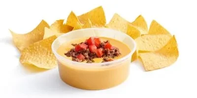Plastic container of queso dip with ground meat, tomatoes, and chips.