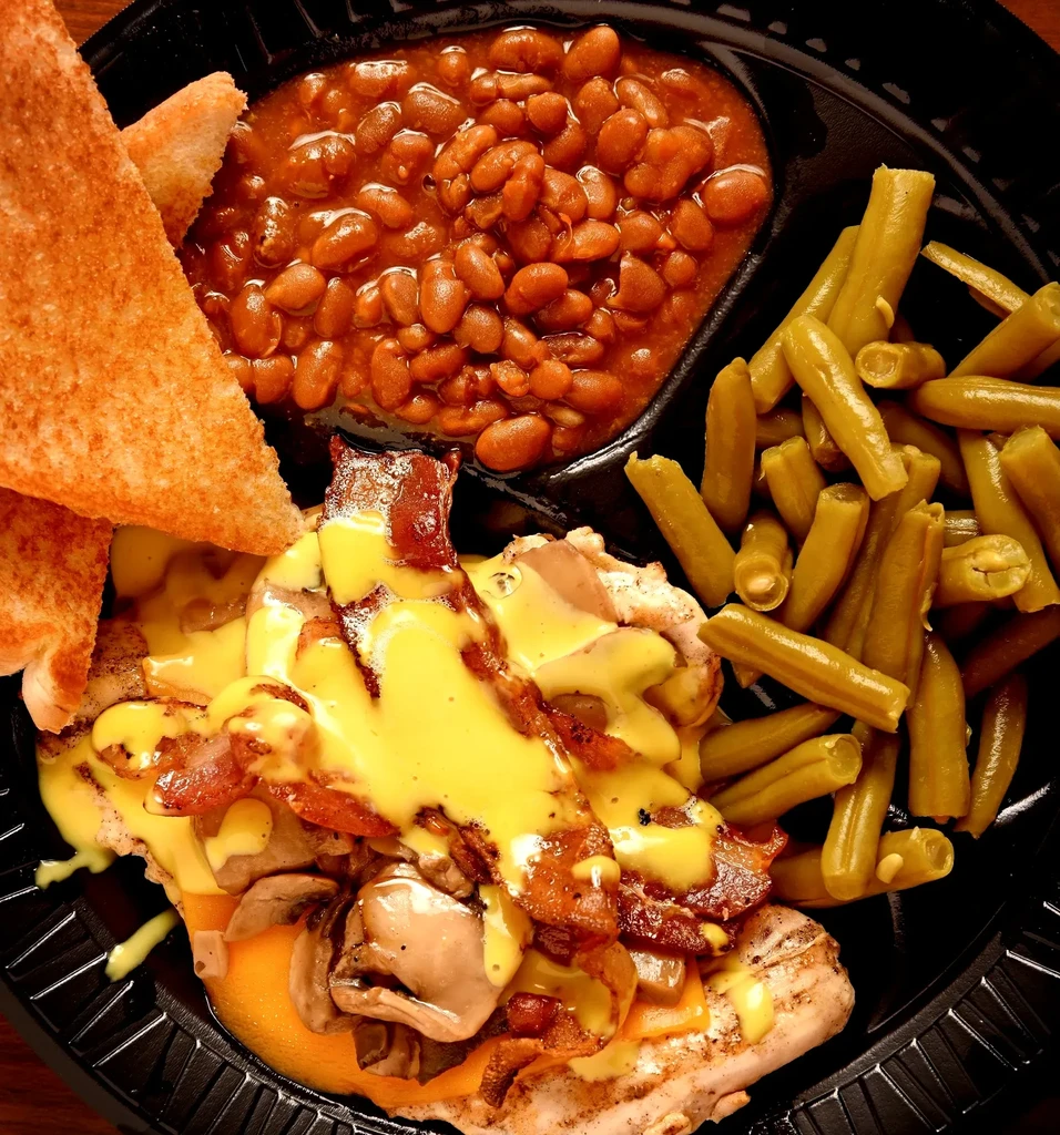 Grilled chicken with cheese, bacon, mushrooms, baked and green beans, toast.