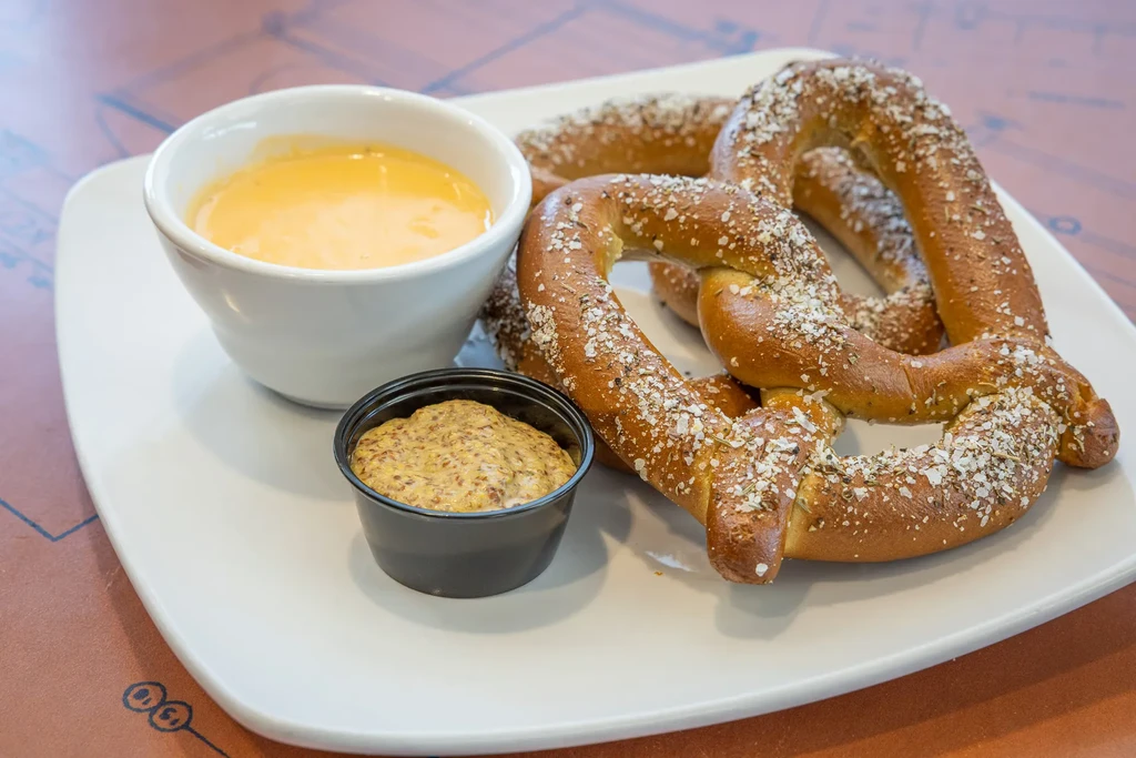Two salted soft pretzels, cheese sauce, and whole-grain mustard.