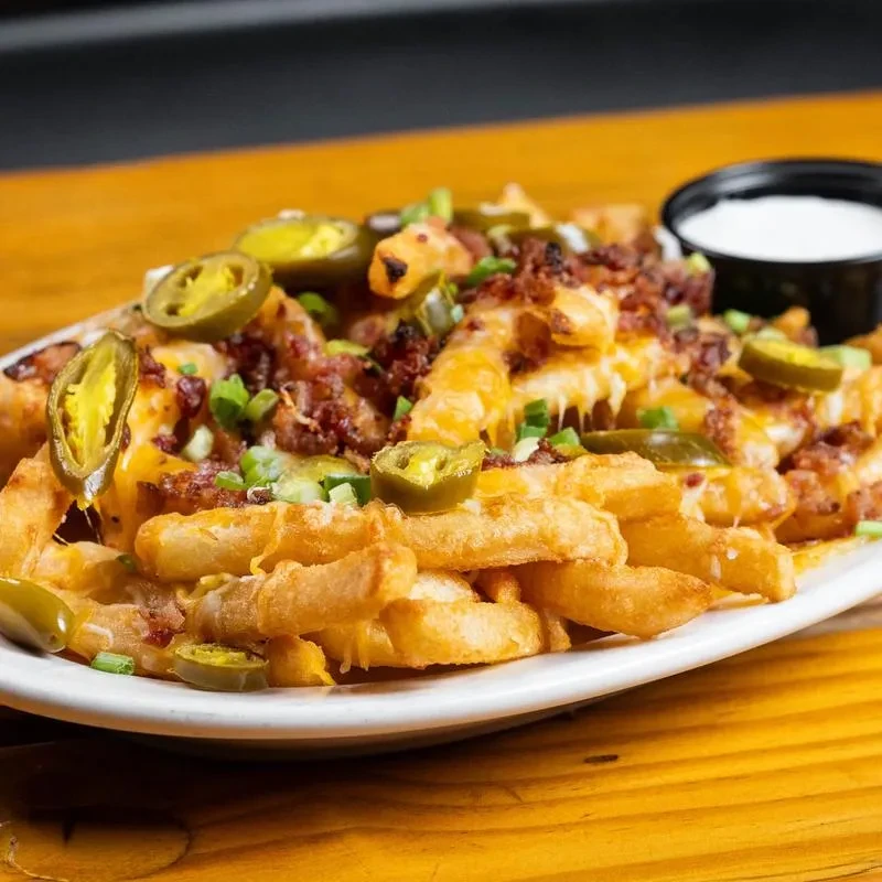 Crinkle-cut fries with melted cheese, bacon, jalapeños, green onions, and sauce.
