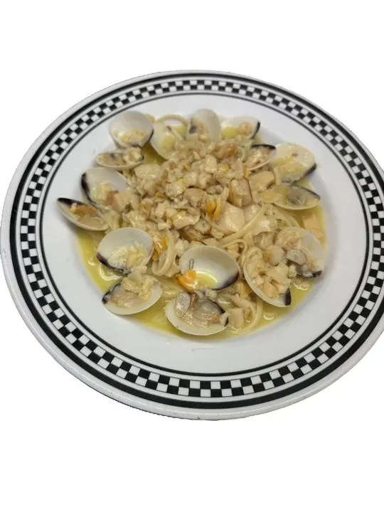 Pasta with clams and creamy sauce on a checkered plate.