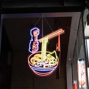 Neon sign showing a ramen bowl, chopsticks, and Japanese characters.