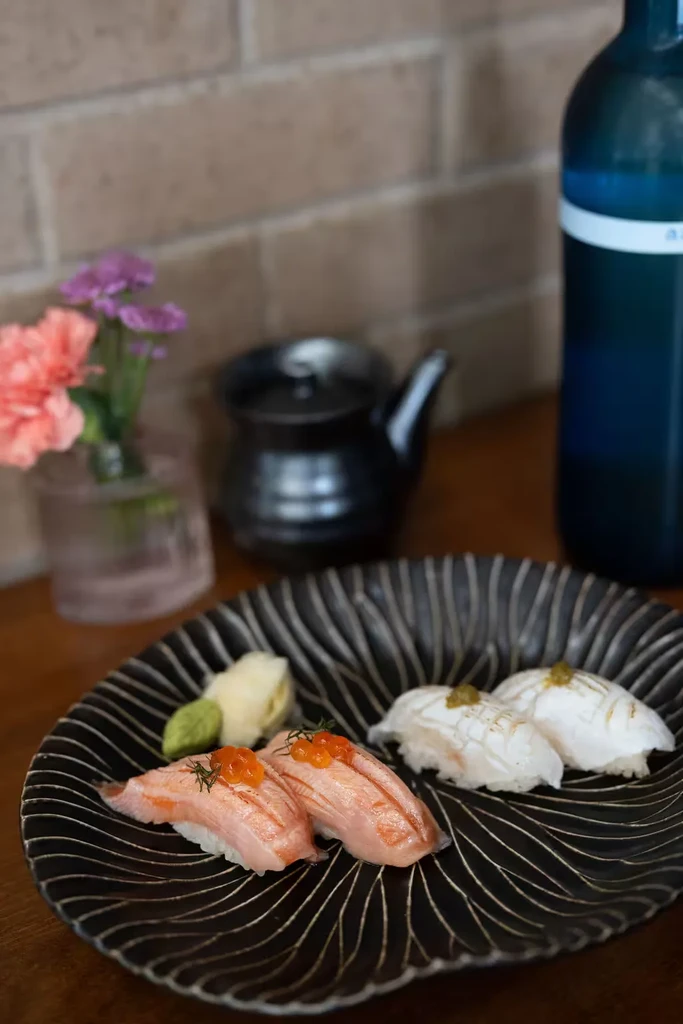 Torched salmon and white fish nigiri, with roe, ginger, and wasabi.